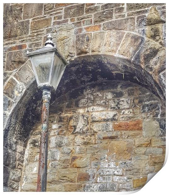 Old lamp beside an old wall Print by HELEN PARKER