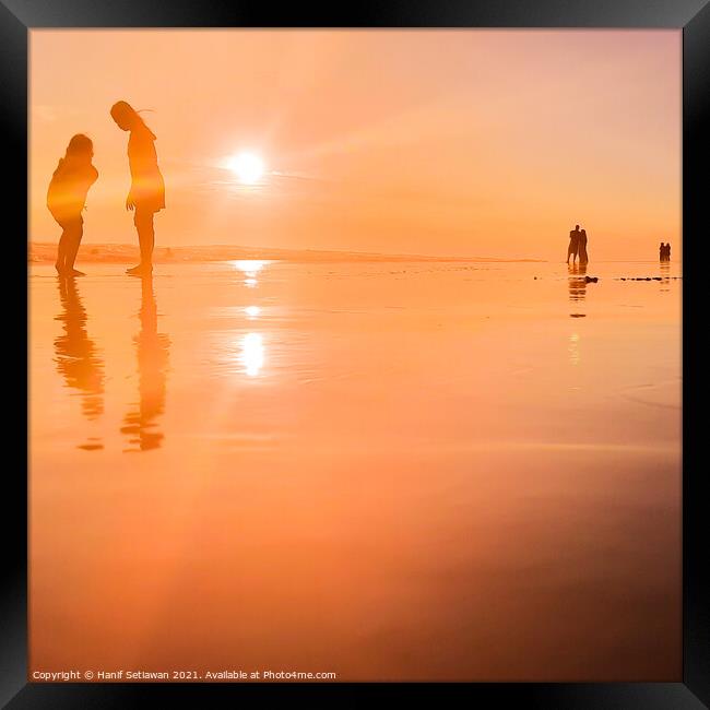 Silhouetted people in a row on sand beach Squared Framed Print by Hanif Setiawan