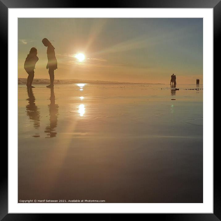 Silhouetted people in a row on sand beach Squared Framed Mounted Print by Hanif Setiawan