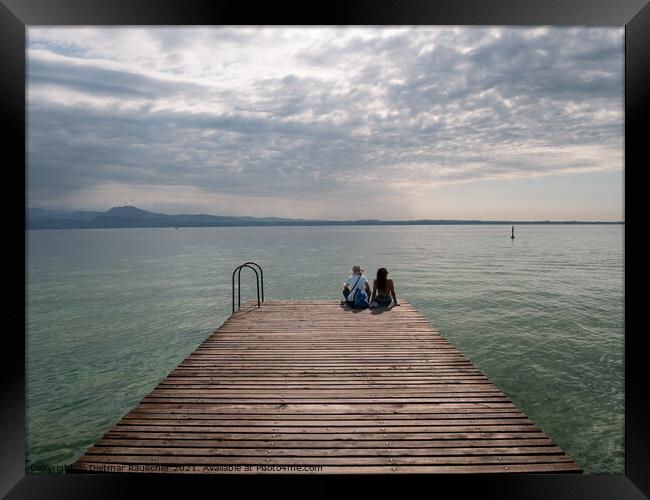 Tourists Sitting on jetty on Lake Garda in Sirmione Framed Print by Dietmar Rauscher