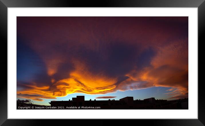 Beautiful sunset sky with red and orange clouds behind the city  Framed Mounted Print by Joaquin Corbalan