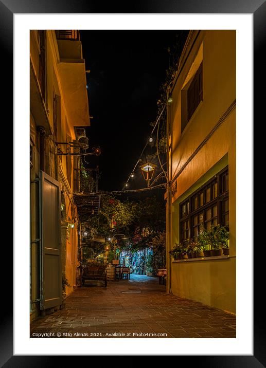 a illuminated narrow alley with gardens and restaurants in the o Framed Mounted Print by Stig Alenäs