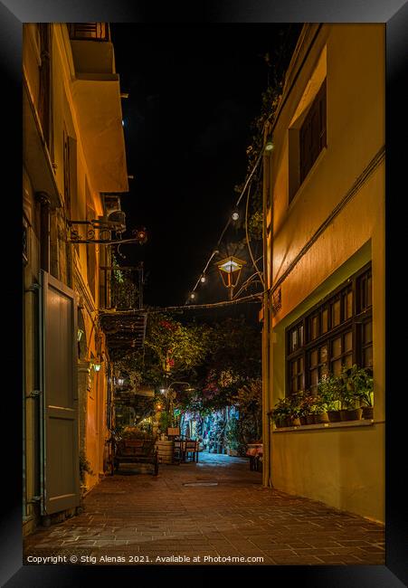 a illuminated narrow alley with gardens and restaurants in the o Framed Print by Stig Alenäs