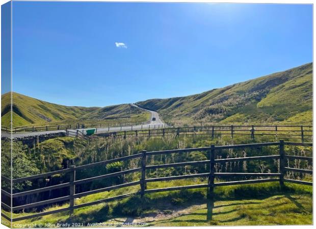 Road running through the Yorkshire Dales, England Canvas Print by John Brady