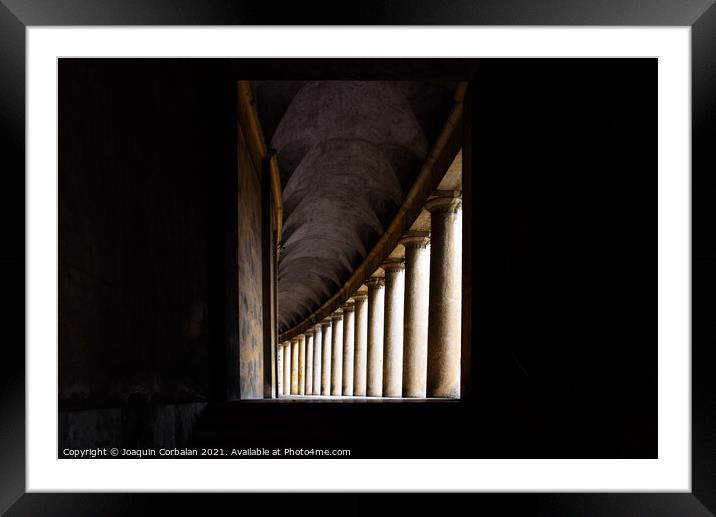 Hallway with monumental columns framed by the dark shadows of a  Framed Mounted Print by Joaquin Corbalan