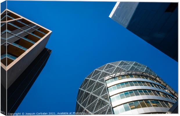 Tall office buildings, viewed from below, modern and rounded, wi Canvas Print by Joaquin Corbalan