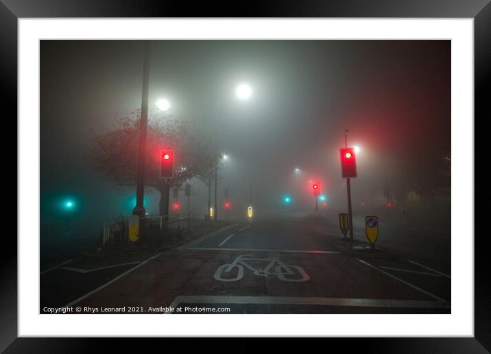 Colored traffic lights and white street lamps shin Framed Mounted Print by Rhys Leonard