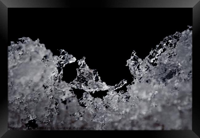 Intricate details of melting ice particles, focus on odd ice crystal Framed Print by Rhys Leonard