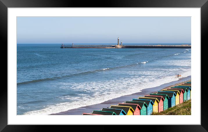 Surfer exiting the water at Whitby Framed Mounted Print by Jason Wells