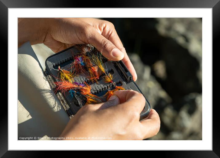 A close up of an asian female selecting salmon fly fishing flies from a box Framed Mounted Print by SnapT Photography