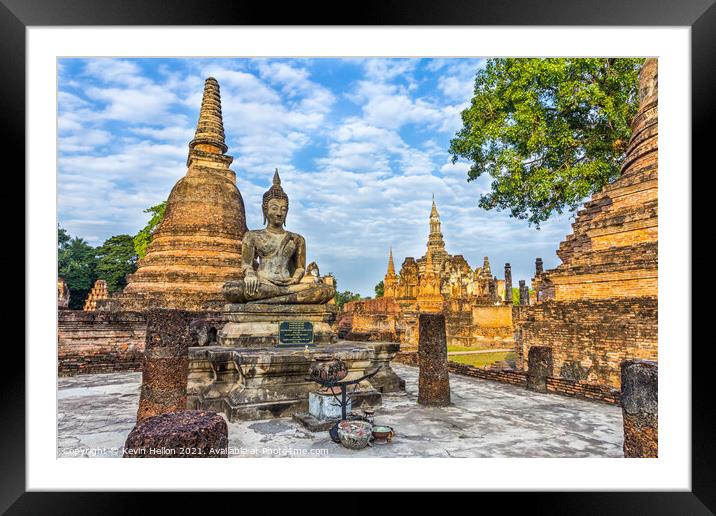 Buddha statue with Wat Mahathat in the background Framed Mounted Print by Kevin Hellon