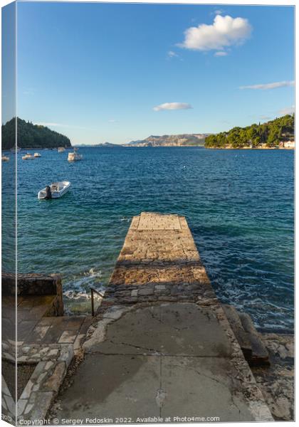 Stone pier in the sea with mountains in the background Canvas Print by Sergey Fedoskin