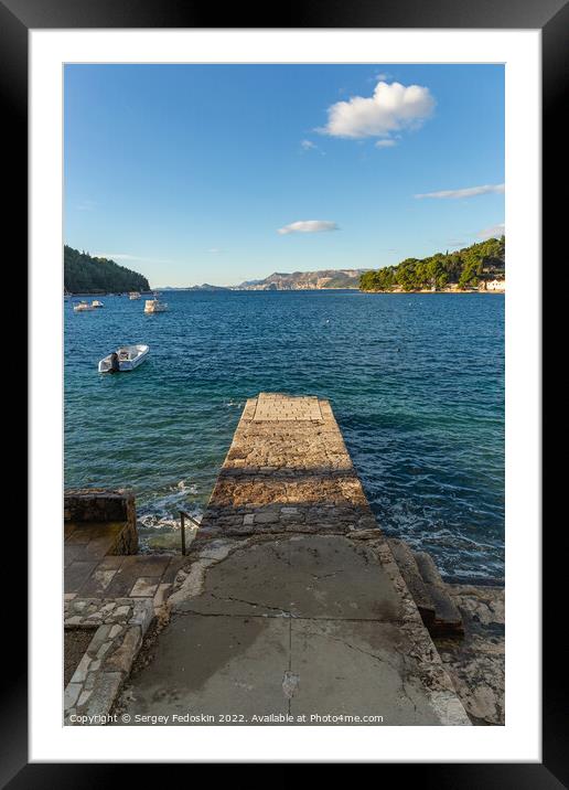 Stone pier in the sea with mountains in the background Framed Mounted Print by Sergey Fedoskin