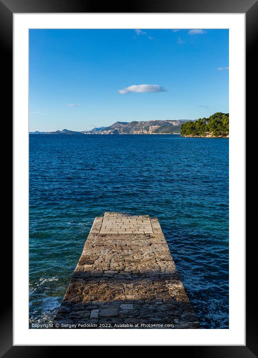 Stone pier in the sea with mountains in the background Framed Mounted Print by Sergey Fedoskin