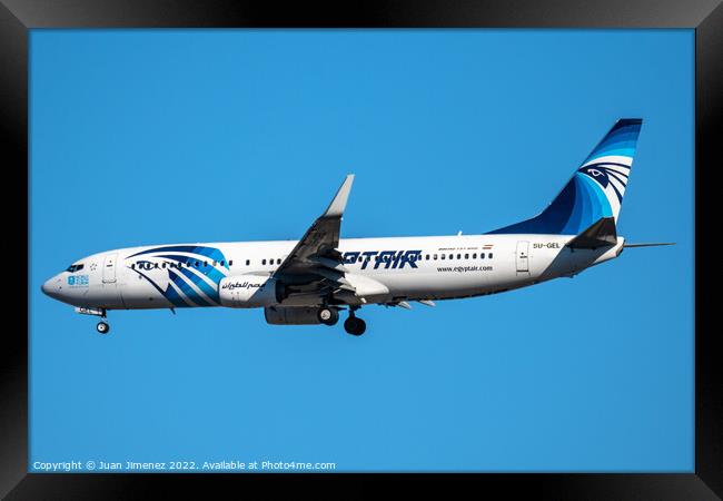 Boeing 737-800 passenger aircraft of the airline Egyptair flying before landing against sky Framed Print by Juan Jimenez