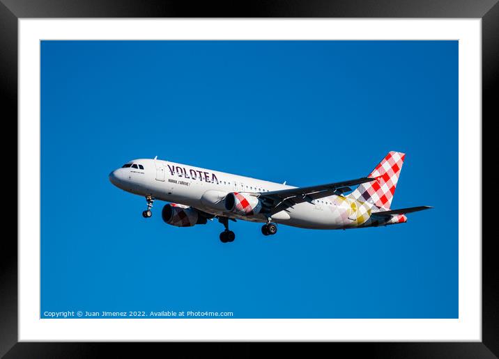 Airbus A320 passenger aircraft of the airline Volotea flying before landing against sky Framed Mounted Print by Juan Jimenez