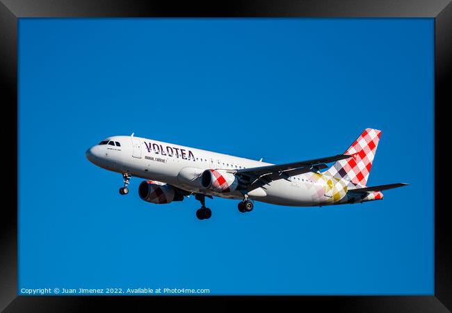 Airbus A320 passenger aircraft of the airline Volotea flying before landing against sky Framed Print by Juan Jimenez