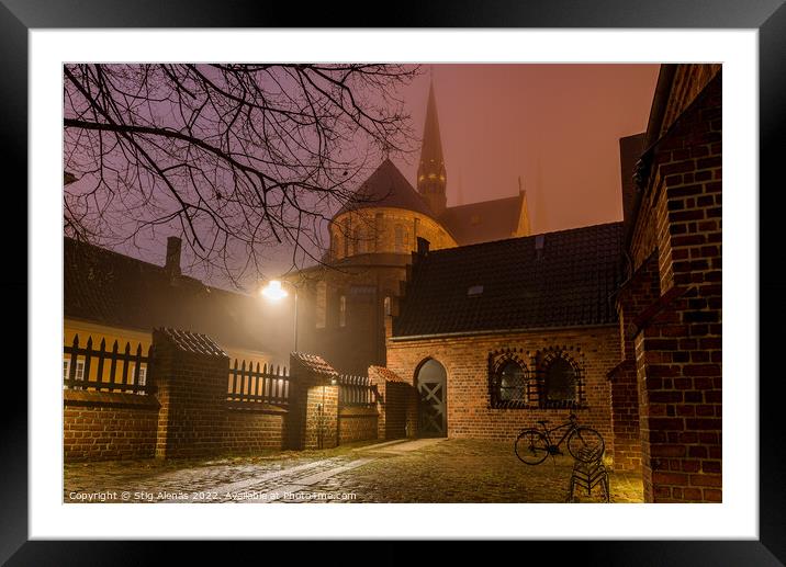 Roskilde cathedral and an illuminated yard with a bike a winter  Framed Mounted Print by Stig Alenäs