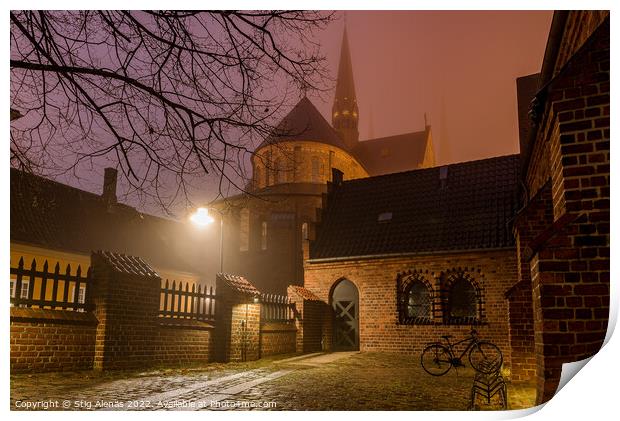 Roskilde cathedral and an illuminated yard with a bike a winter  Print by Stig Alenäs