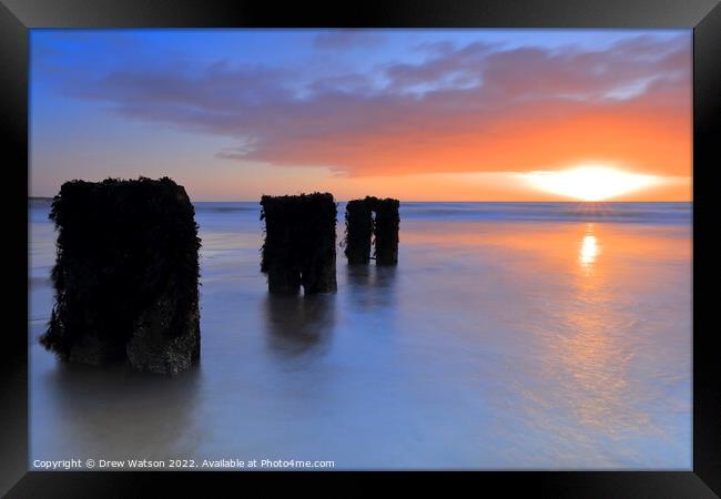 Groynes on the beach at sunrise Framed Print by Drew Watson