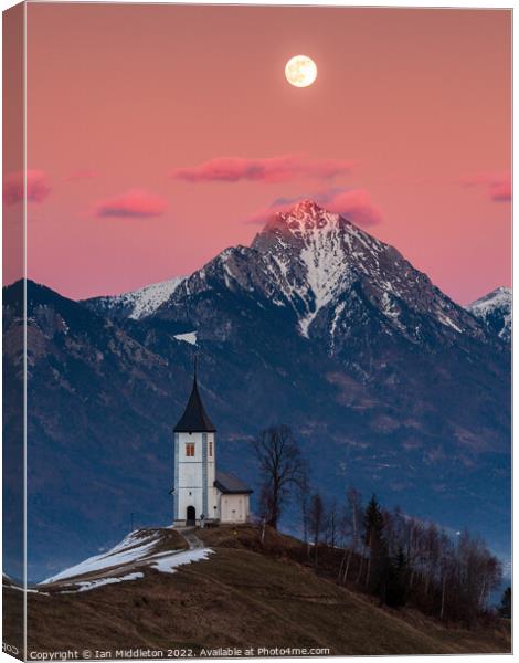 Full moon rising over Jamnik church and Storzic at sunset Canvas Print by Ian Middleton