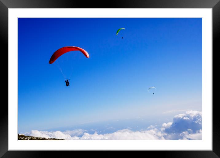 Athletes use an ultralight flexible glider, paraglider, to fly a Framed Mounted Print by Joaquin Corbalan