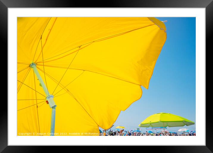 Beach holiday background, with a large yellow umbrella in the fo Framed Mounted Print by Joaquin Corbalan