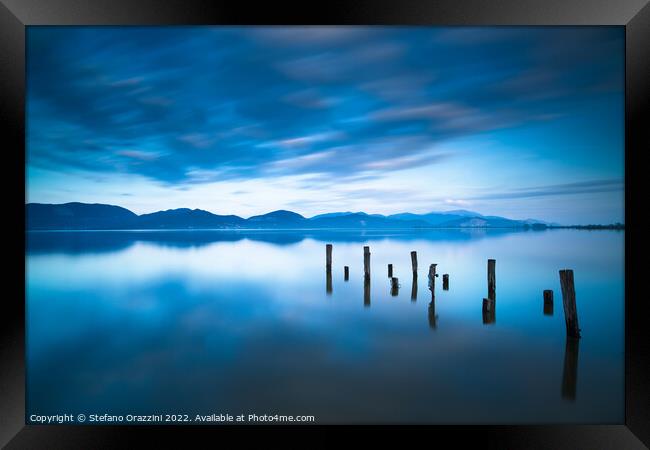 Remains of a wooden jetty in a blue lake Framed Print by Stefano Orazzini