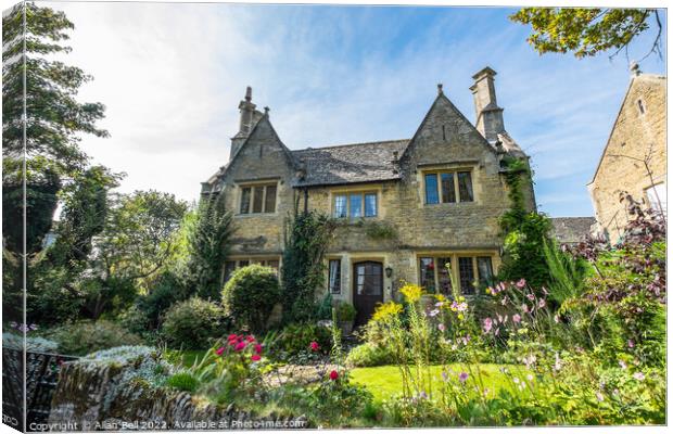 Riverside house and garden Bourton-on-the-Water. Canvas Print by Allan Bell