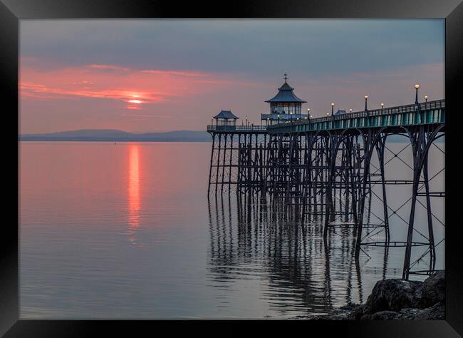 Clevedon Pier at sunset with it legs reflecting in the sea Framed Print by Rory Hailes