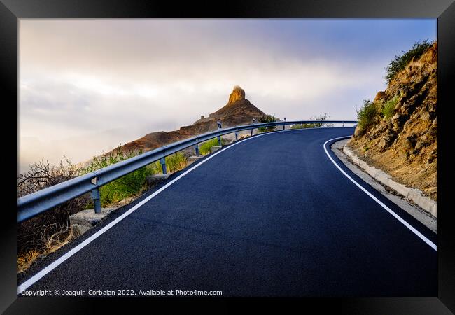 A mountain road approaches the famous Roque Bentayga through the Framed Print by Joaquin Corbalan