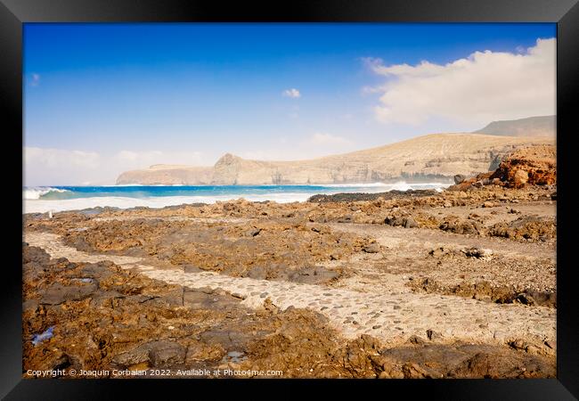 Atlantic rocky coast washed by the ocean on a sunny day with blu Framed Print by Joaquin Corbalan