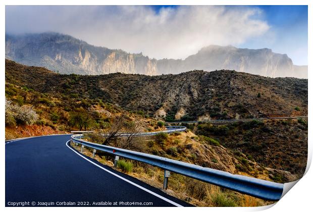 Winding road leads to high mountains with clouds to escape the r Print by Joaquin Corbalan