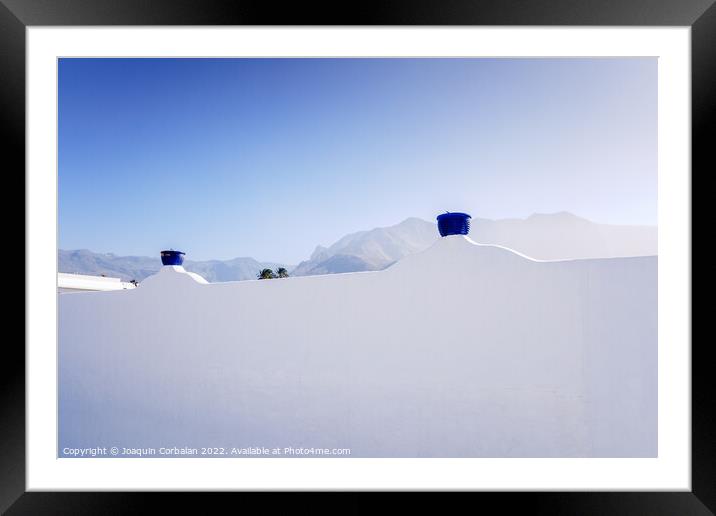 A sunny day to see the mountains behind the whitewashed wall of  Framed Mounted Print by Joaquin Corbalan