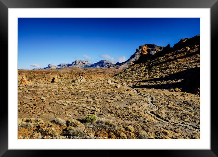 Path runs along the slopes of some steep mountains. Framed Mounted Print by Joaquin Corbalan