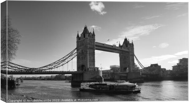 Monochrome tower bridge with tourist boat Canvas Print by Ann Biddlecombe