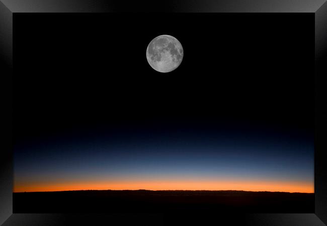 Near full moon against a sunrise from an aircraft Framed Print by Gordon Dixon