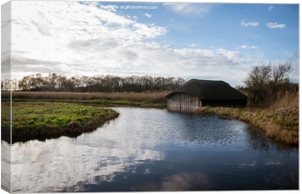 Blue skies over Hickling Broad boat house Canvas Print by Christopher Keeley