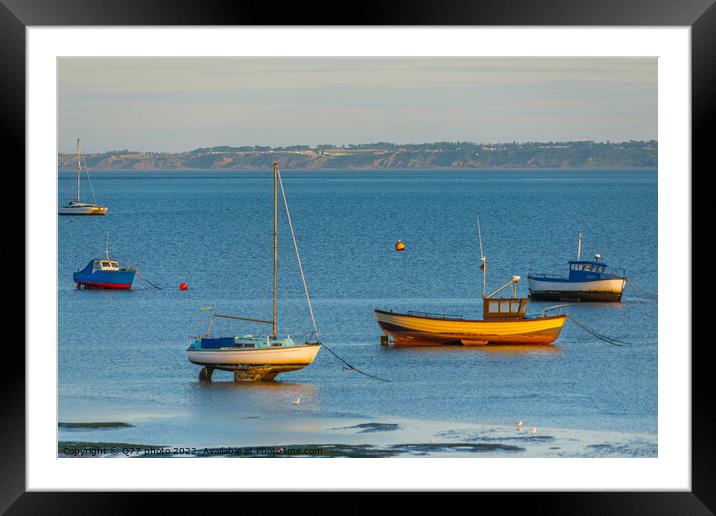 Moored boat illuminated by the rays of the setting sun on the shoal during low tide Framed Mounted Print by Q77 photo