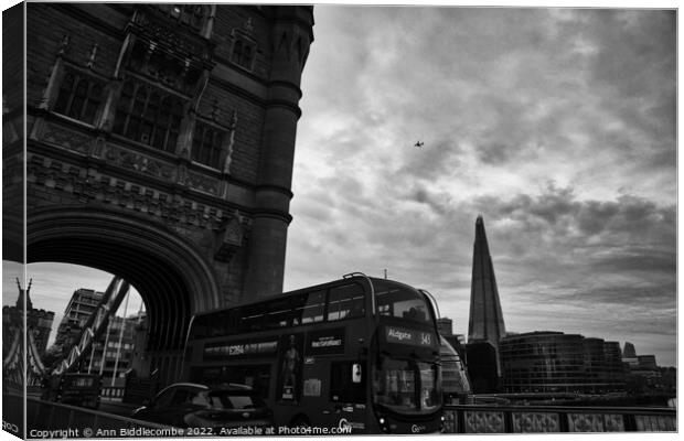 On Tower Bridge as a bus goes past Canvas Print by Ann Biddlecombe