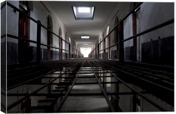 Light at the end of a corridor of cells in an abandoned prison in Kuala Lumpur Canvas Print by Gordon Dixon