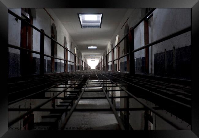 Light at the end of a corridor of cells in an abandoned prison in Kuala Lumpur Framed Print by Gordon Dixon