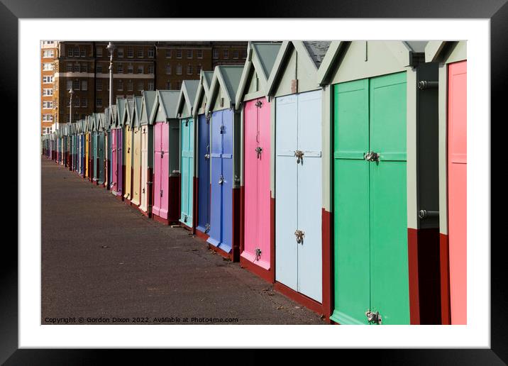 A row of beach huts stretching to infinity (almost) on the seafront - Brighton and Hove Framed Mounted Print by Gordon Dixon