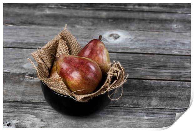 Raw whole pears inside of bowl on aged wooden table in close up  Print by Thomas Baker