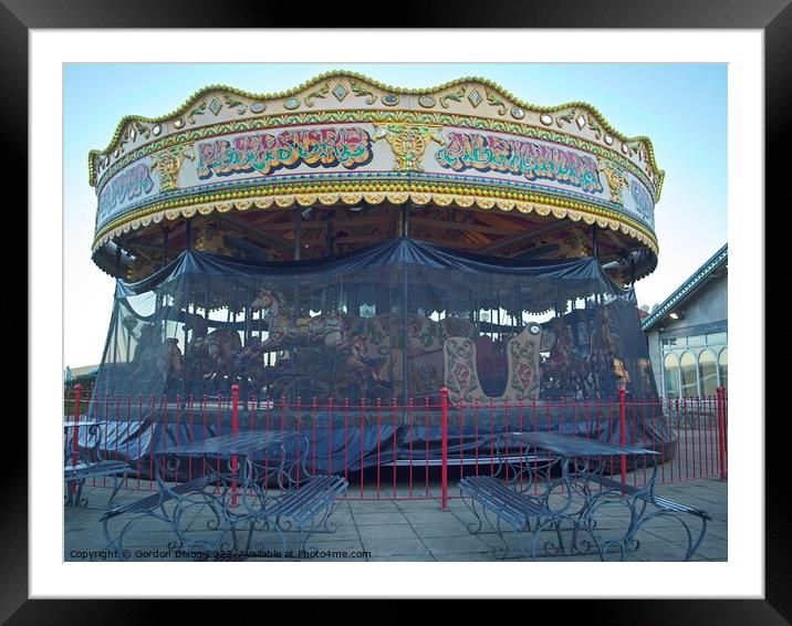 Carousel and it's horses put to bed for the winter at a funfair in Weymouth Framed Mounted Print by Gordon Dixon