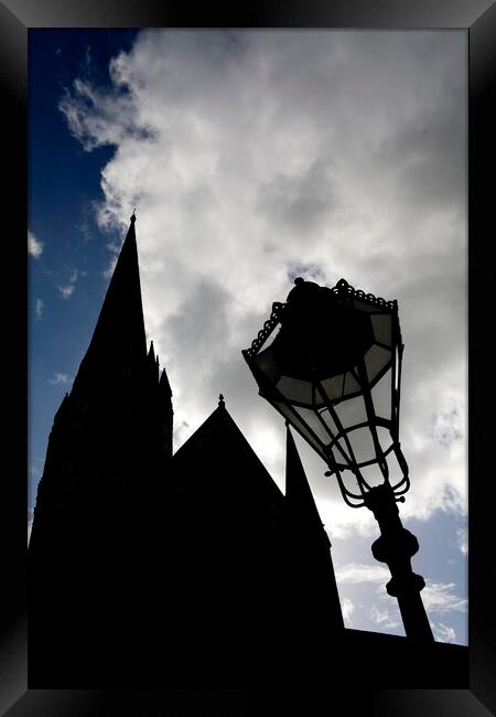 Iconic spire of Salisbury Cathedral and ornate street lamp in silhouette Framed Print by Gordon Dixon