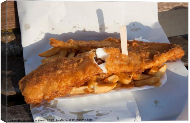 Golden brown battered fish with chips and a wooden fork in paper - delicious Canvas Print by Gordon Dixon