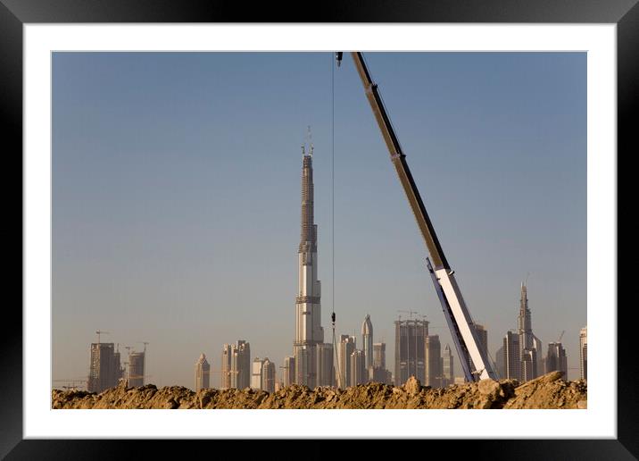 Checking it's vertical - Sheik Zayed Road skyline during construction of the Burj Khalifa, Dubai Framed Mounted Print by Gordon Dixon