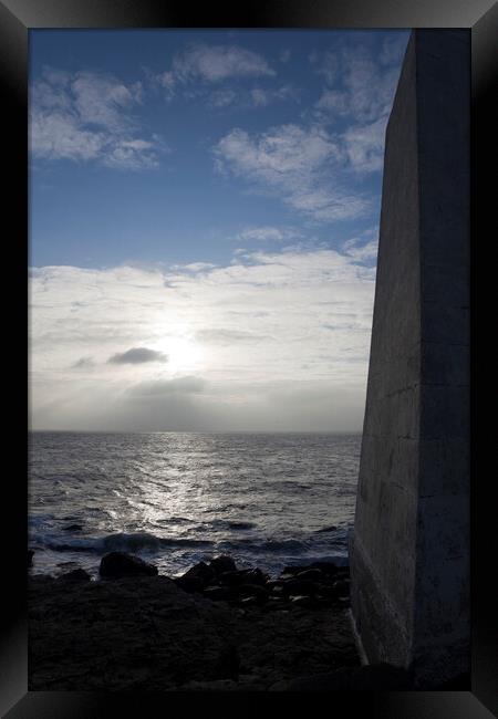 A dark obelisk looks over the sea at Portland Bill Dorset towards the setting sun Framed Print by Gordon Dixon