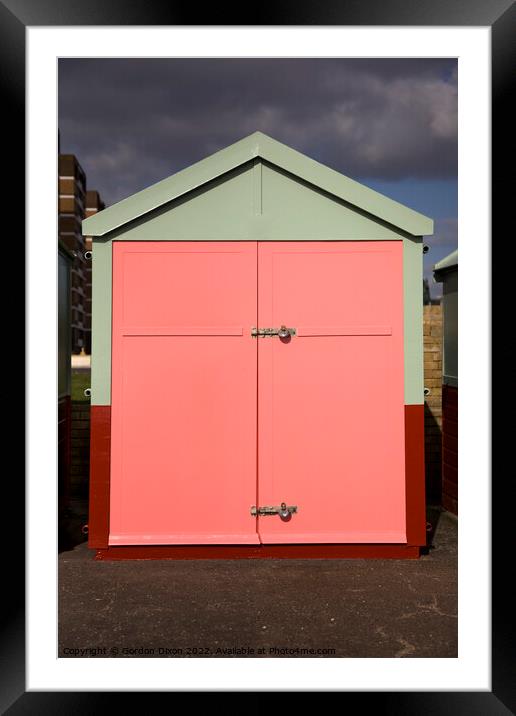Peach colour beach hut against stormy sky Framed Mounted Print by Gordon Dixon